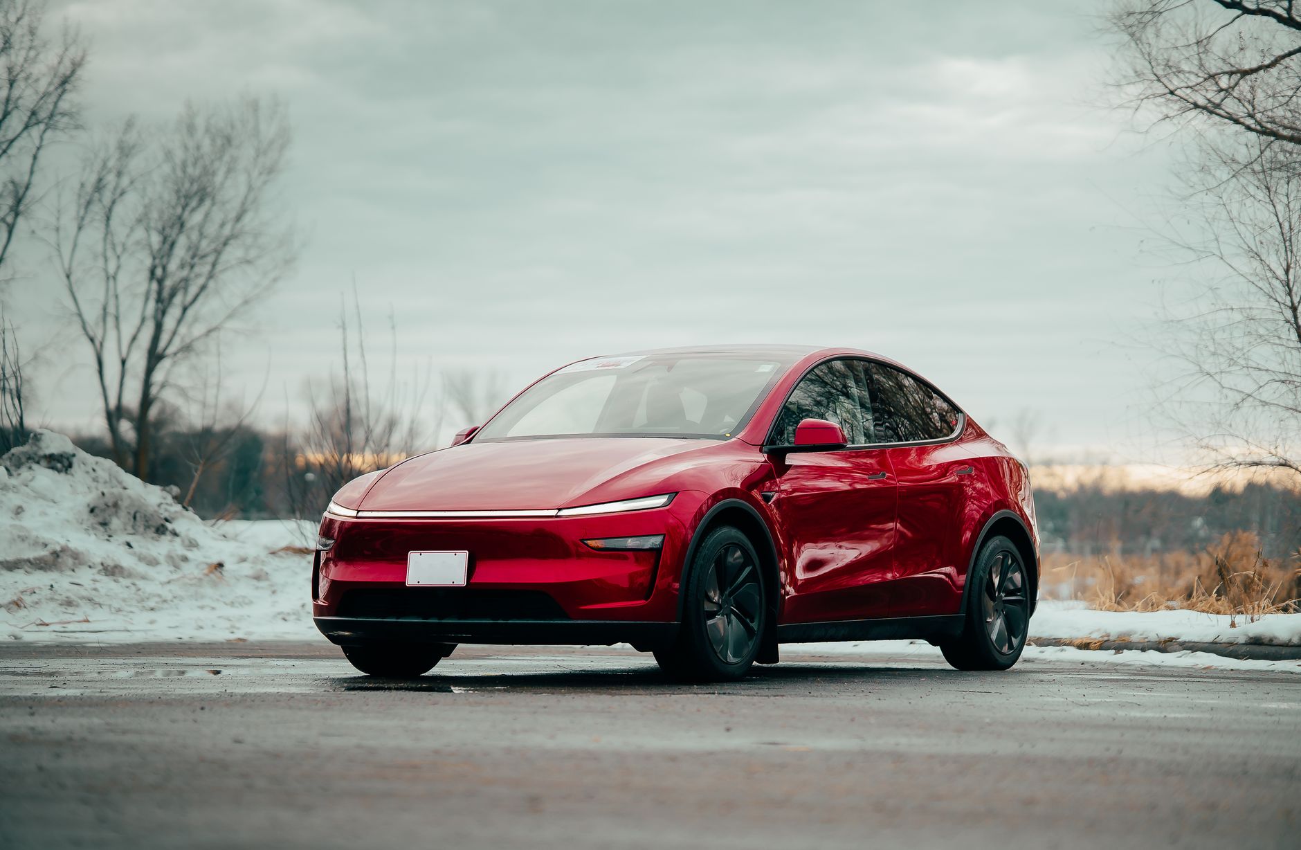 Czerwony samochód elektryczny zaparkowany zimą na zewnątrz